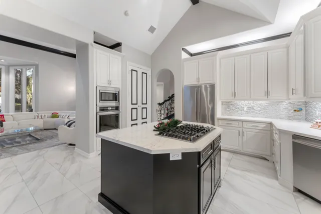 a kitchen with stainless steel appliances kitchen island a sink stove and refrigerator