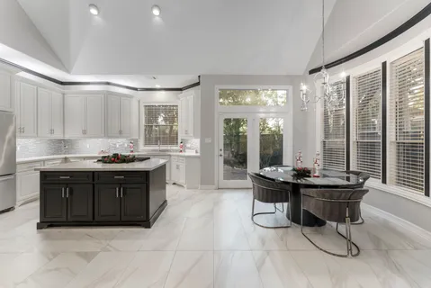 a kitchen with a sink table and chairs