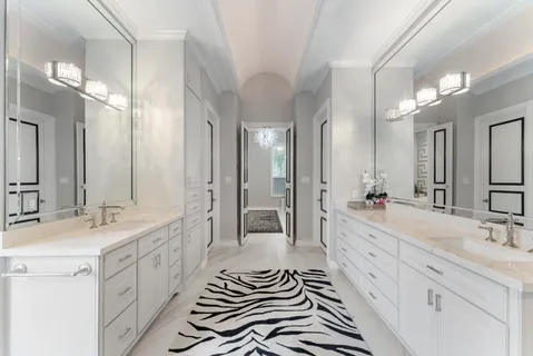 a spacious bathroom with a double vanity sink a mirror and a shower