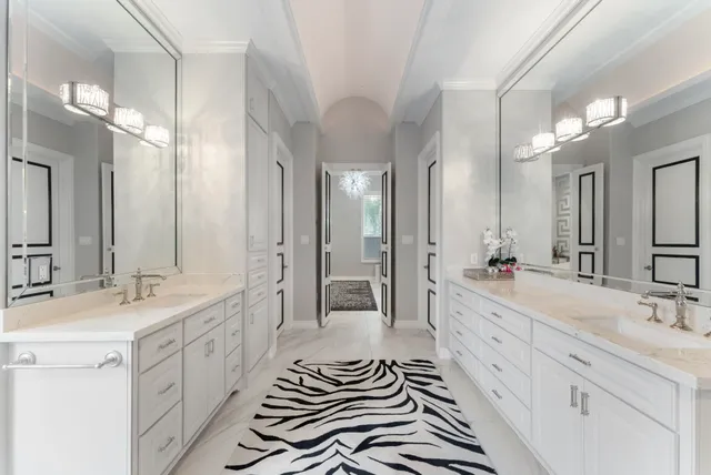 a spacious bathroom with a double vanity sink a mirror and a shower