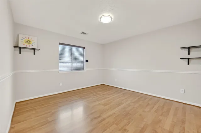 an empty room with windows and cabinet