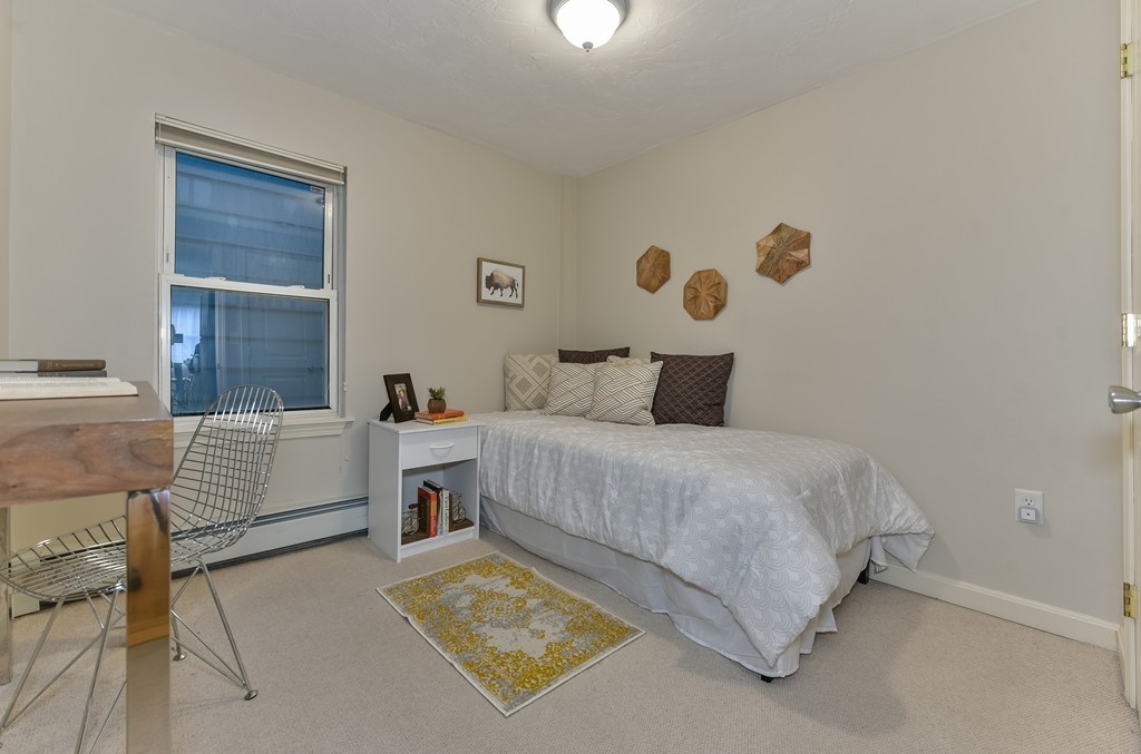 95 Second Street, Unit 3 Cambridge, MA 02141 - Photo 4 of 13 a bedroom with a white bed and a couch