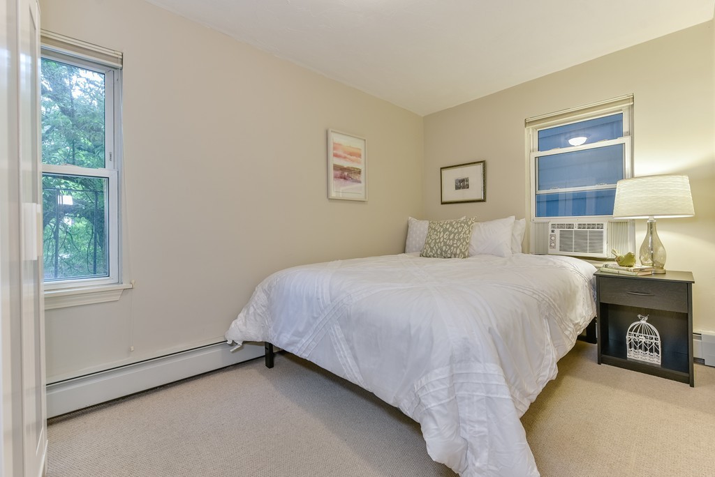 95 Second Street, Unit 3 Cambridge, MA 02141 - Photo 5 of 13 a bedroom with a bed and a lamp on dresser next to a window