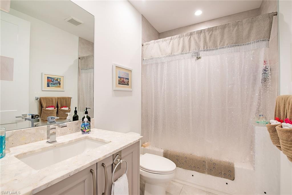 1111 Central Avenue, Unit 207 Naples, FL 34102 - Photo 11 of 18 a bathroom with a sink a toilet and a mirror