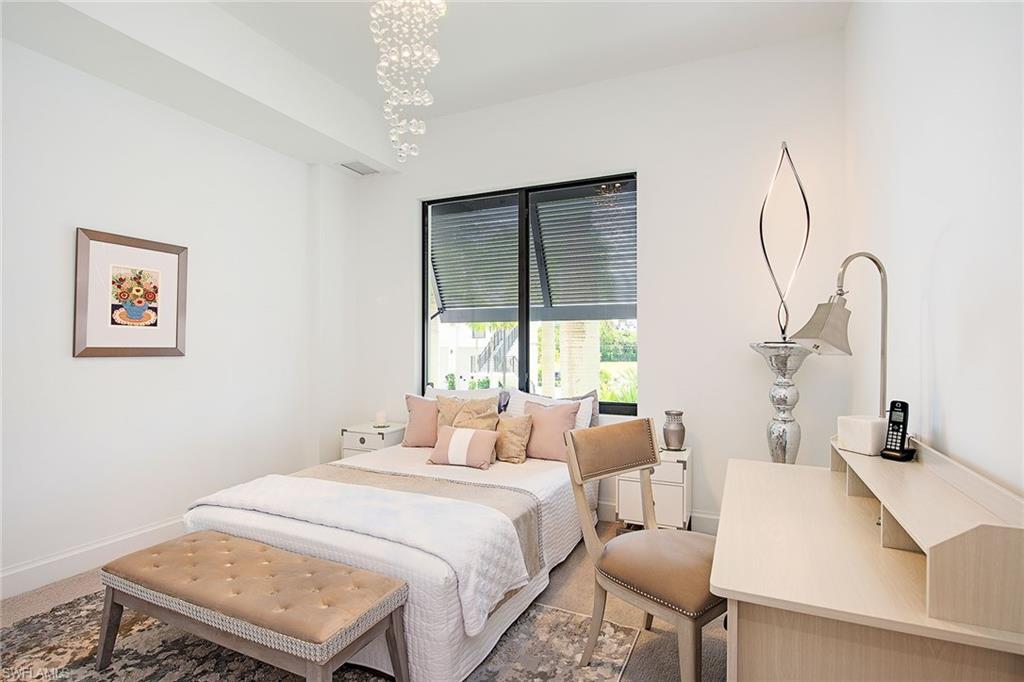 1111 Central Avenue, Unit 207 Naples, FL 34102 - Photo 10 of 18 a bedroom with a bed and a table