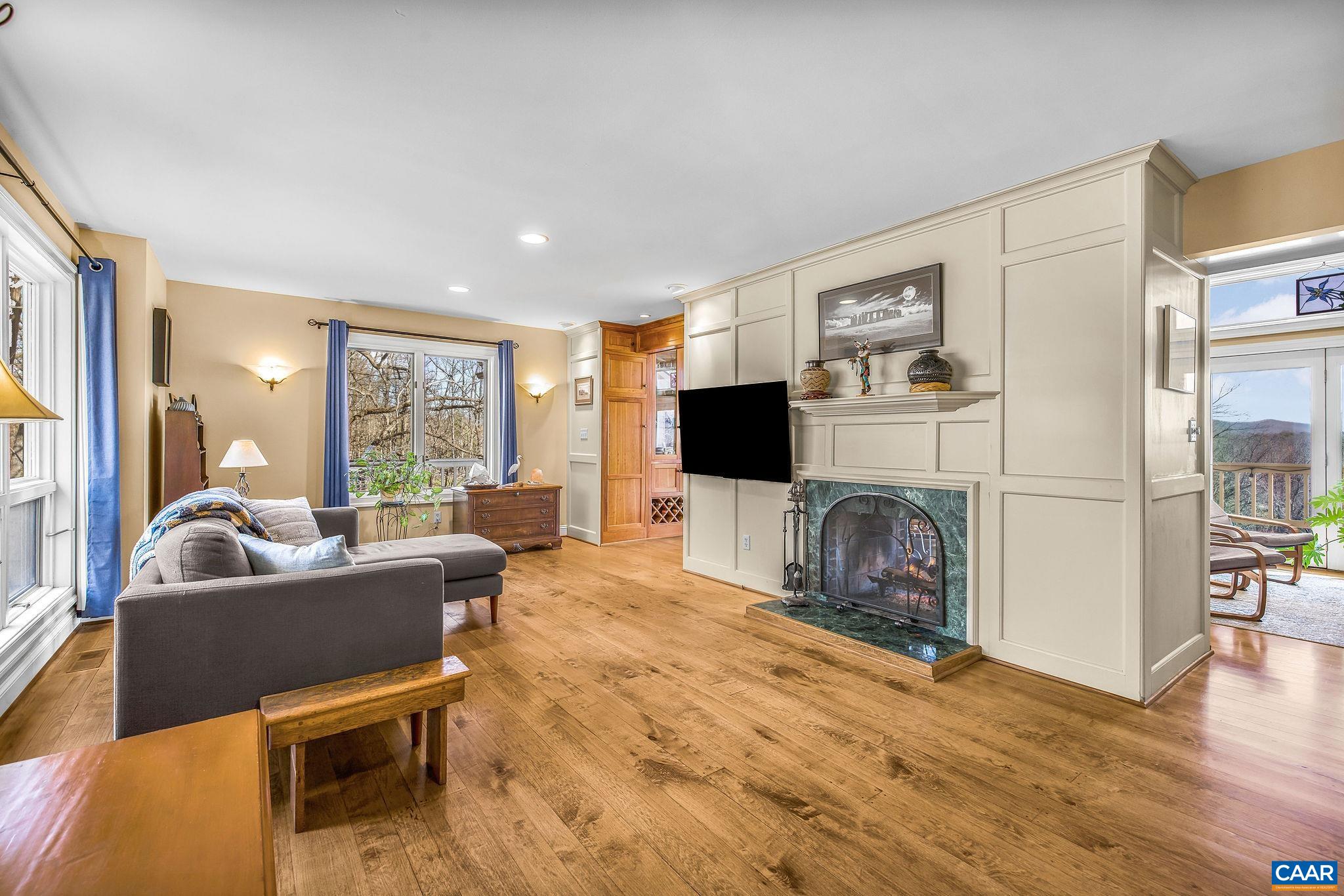 987 Rodes Farm Drive Nellysford, VA 22958 - Photo 10 of 74 a living room with furniture a flat screen tv and a fireplace