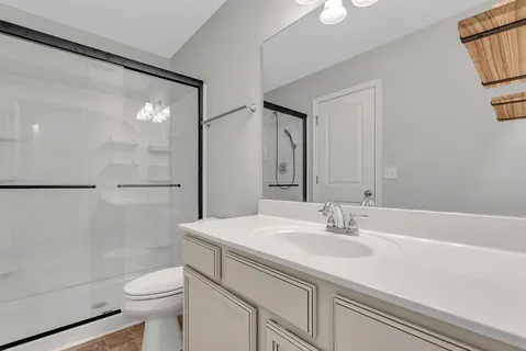 a bathroom with a sink a toilet and shower