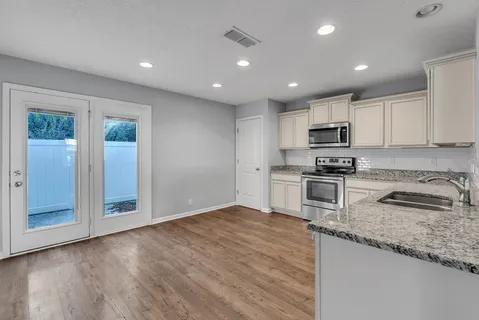 a kitchen with granite countertop a stove a sink and a refrigerator