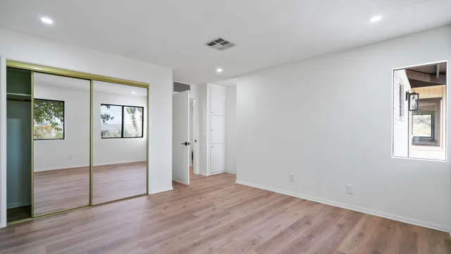 an empty room with closet and windows