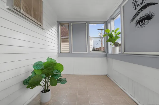 a white vase with white and yellow flowers