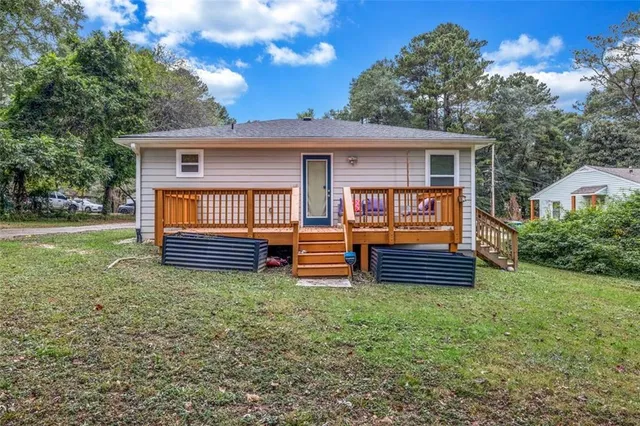 a view of a backyard with wooden fence and large trees