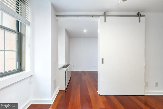 a view of a room with wooden floor and a window