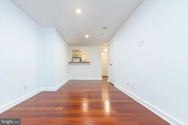 a view of empty room with wooden floor