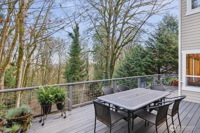 a balcony with wooden floor table and chairs