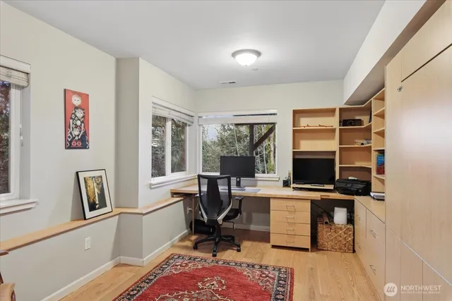 a view of a workspace with furniture and a window