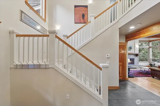 a view of staircase with lots of frames on wall and a window