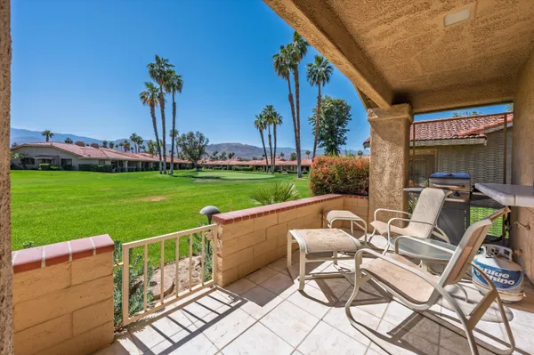 a view of a chairs and table in patio with a yard