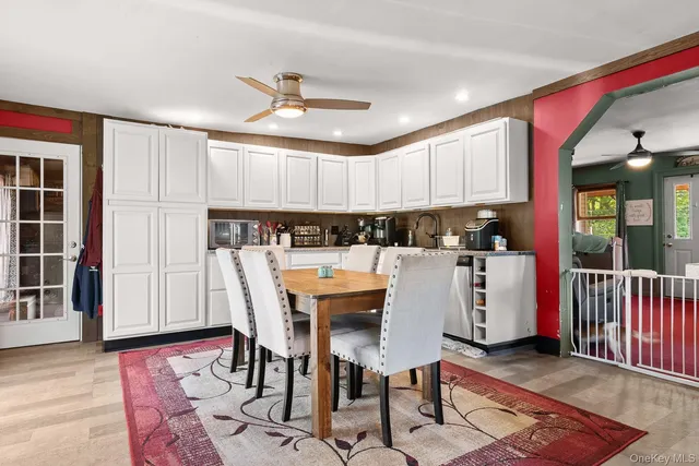 a kitchen with stainless steel appliances kitchen island granite countertop a refrigerator a stove top oven and a dining table with wooden floor