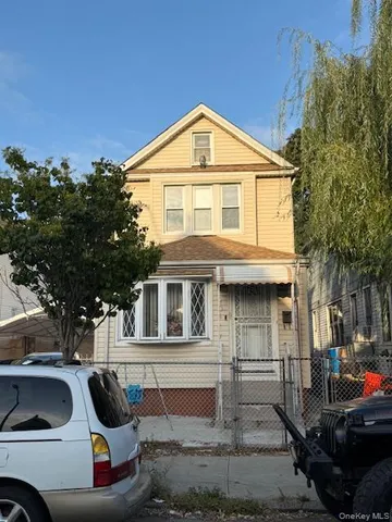 a front view of a house with cars parked