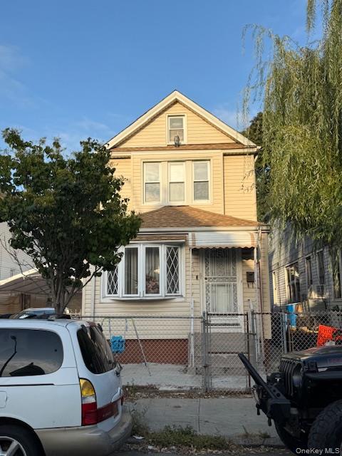 a front view of a house with cars parked