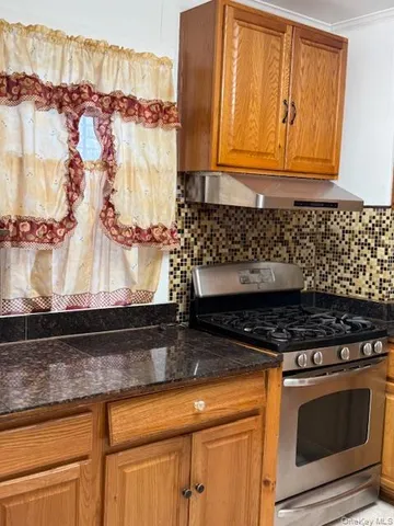 a kitchen with granite countertop a stove and a microwave
