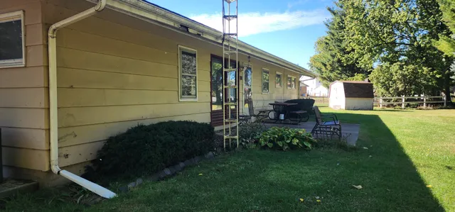 a backyard of a house with table and chairs