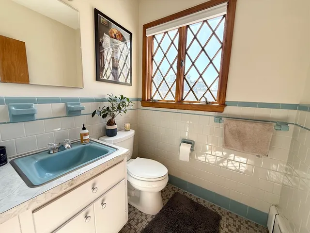 a bathroom with a sink a toilet and a window