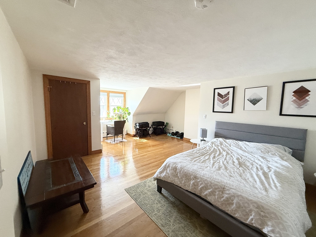 920 East 4th Street, Unit 2 Boston, MA 02127 - Photo 6 of 11 a bedroom with a bed and wooden floor