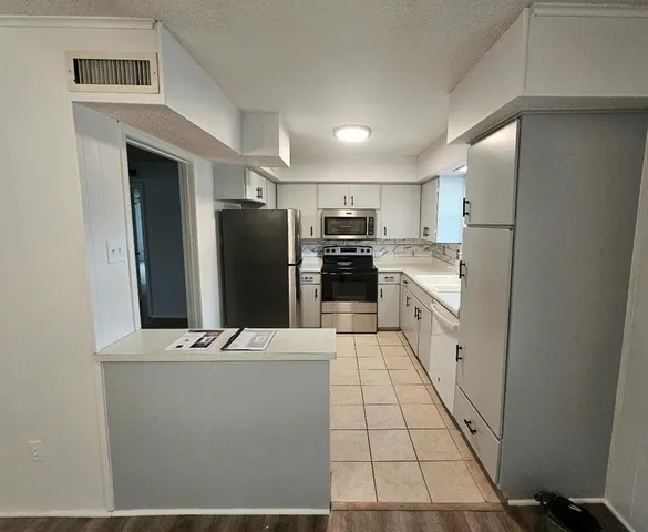 a kitchen with stainless steel appliances a refrigerator sink and stove