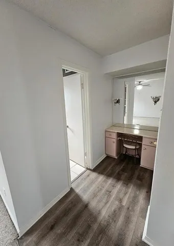 an empty room with wooden floor and a sink