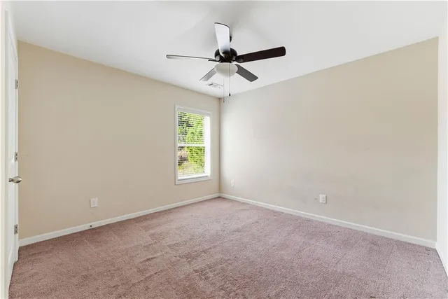 an empty room with a window and a ceiling fan