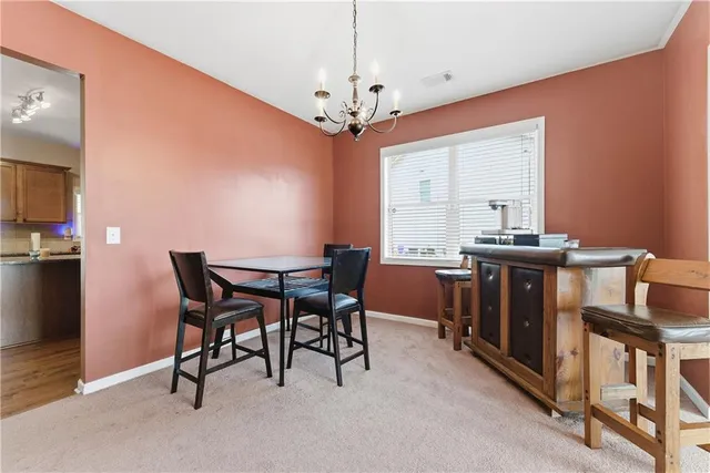 a view of a dining room with furniture and chandelier