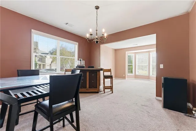 a dining room with furniture a chandelier and a rug