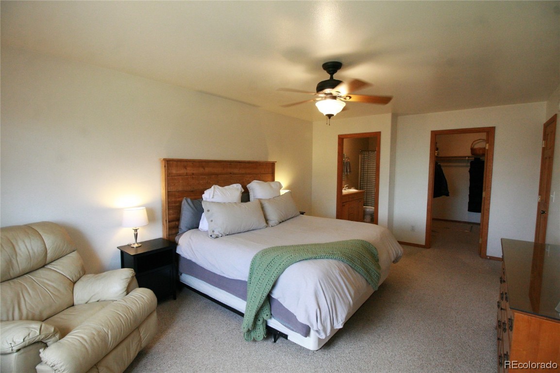 310 Honeysuckle Drive Hayden, CO 81639 - Photo 10 of 22 a bedroom with a bed couch ceiling fan and a chandelier