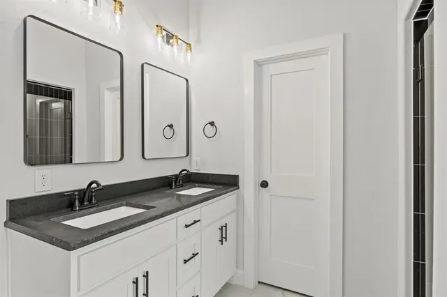 a bathroom with a granite countertop sink and a mirror