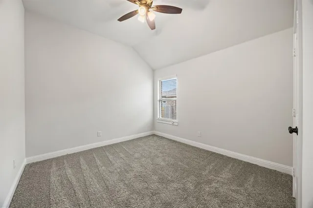 an empty room with chandelier fan