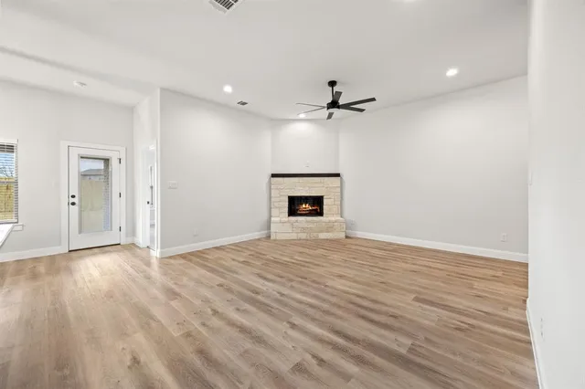 a view of empty room with wooden floor and fireplace