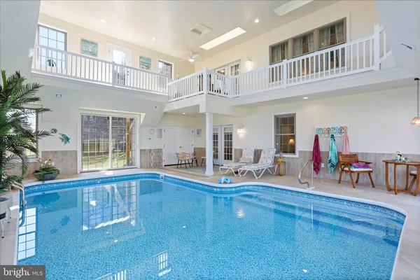 a kitchen with stainless steel appliances granite countertop a sink a stove a refrigerator and island with wooden floor