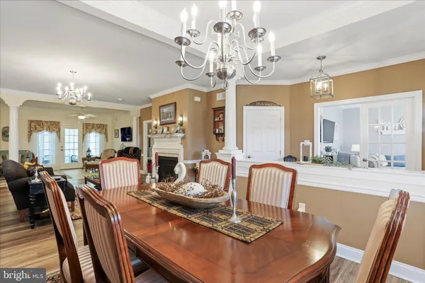 a view of a dining room and livingroom with furniture wooden floor a chandelier