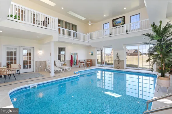 a living room with furniture kitchen view and a wooden floor