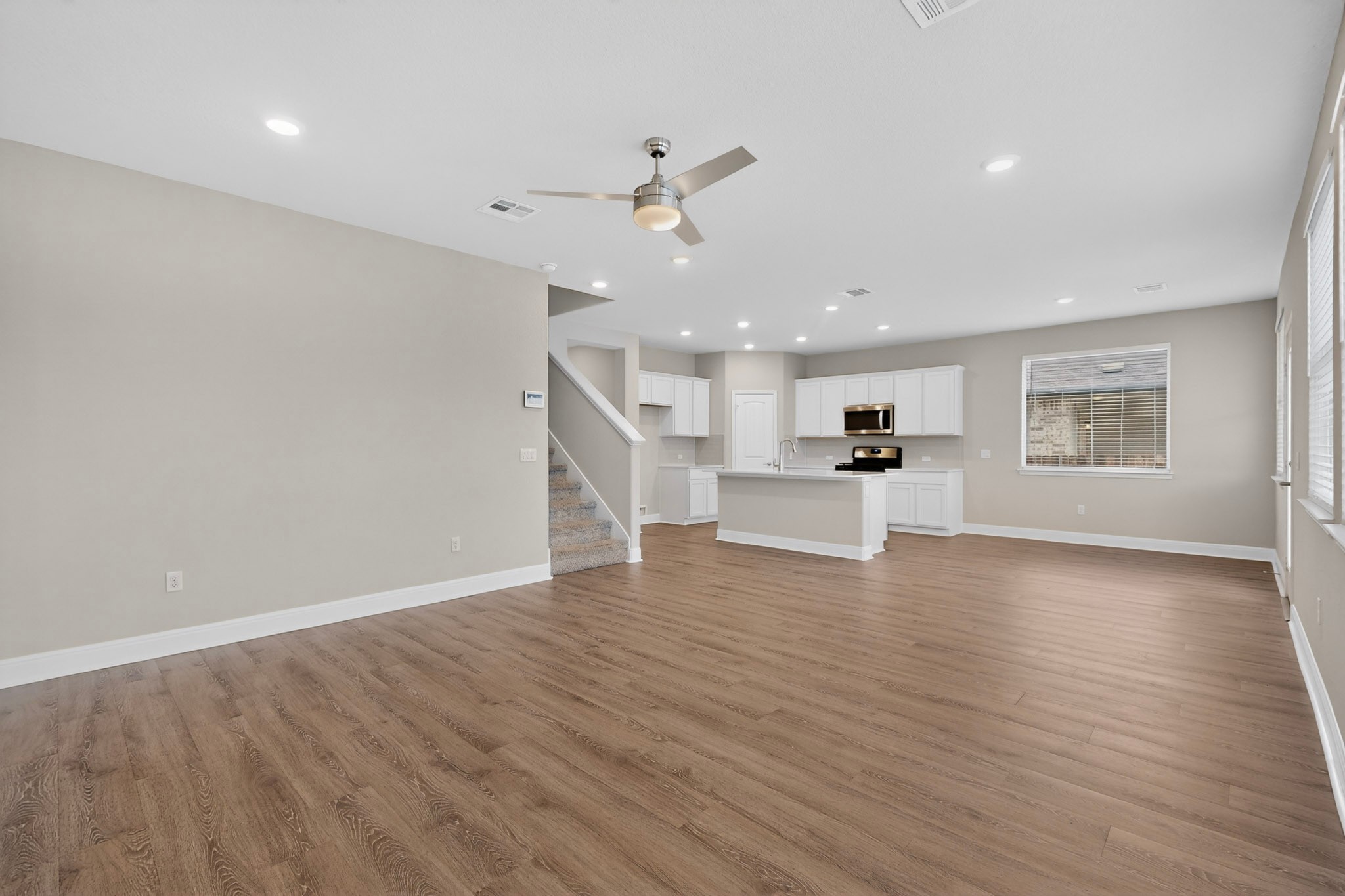 16809 Guido Cove Pflugerville, TX 78660 - Photo 7 of 40 Open-concept living area featuring wood-finish flooring, recessed lighting, and a modern ceiling fan