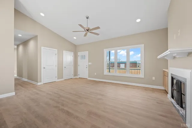 a view of an empty room with a window and fireplace