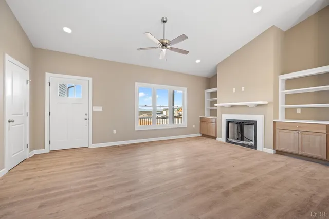 a view of an empty room with window and fire place