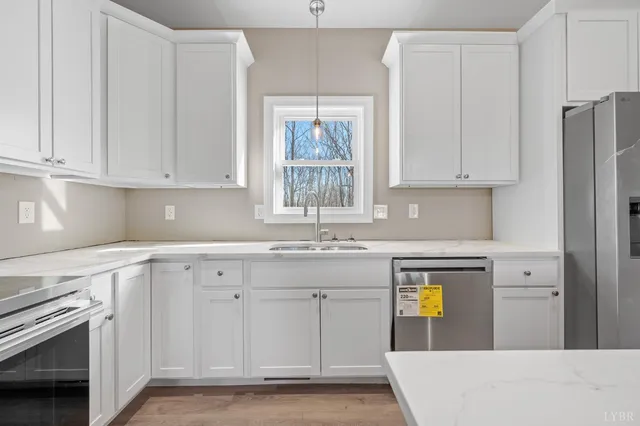 a kitchen with granite countertop white cabinets and stainless steel appliances