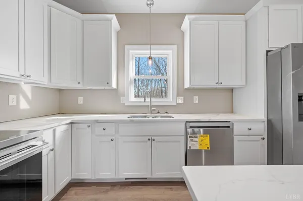 a kitchen with granite countertop white cabinets and stainless steel appliances