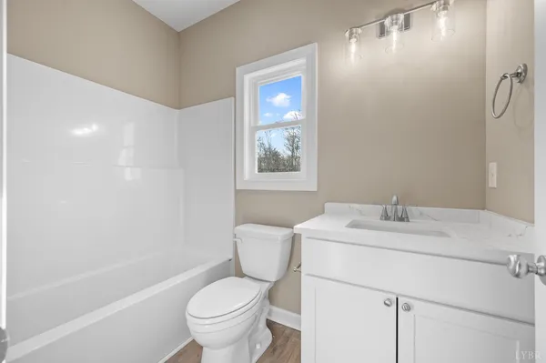 a bathroom with a sink toilet vanity and tub
