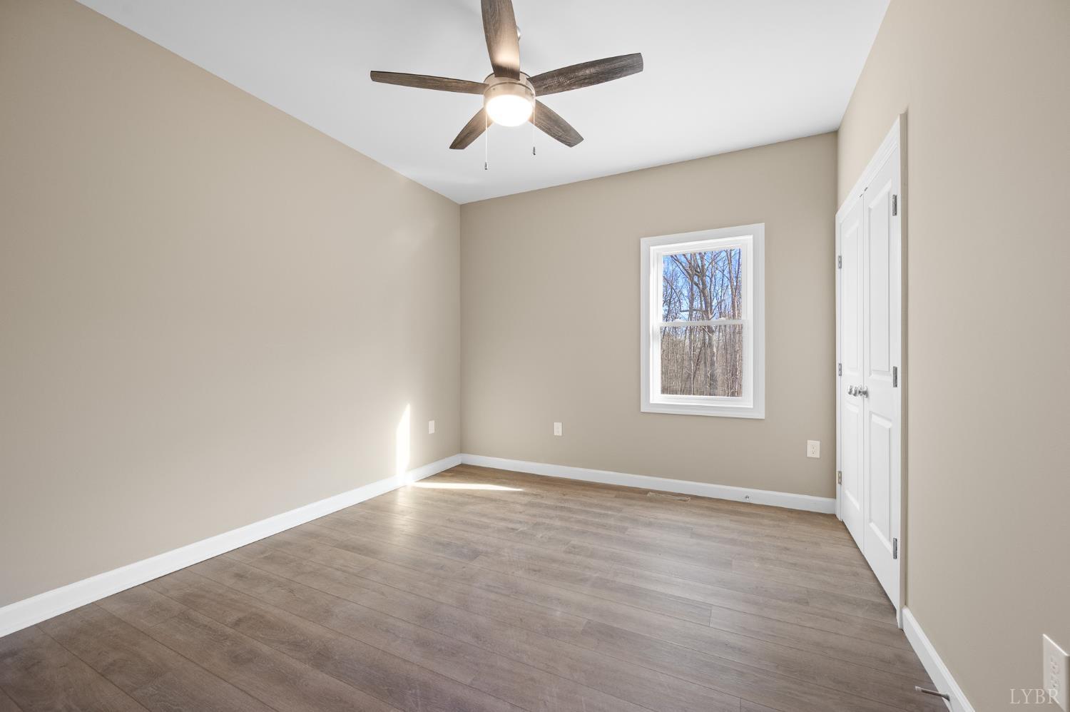 1720 Oak Rdg Road Appomattox, VA 24522 - Photo 20 of 53 an empty room with wooden floor chandelier fan and windows