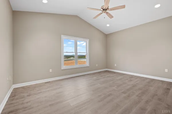 an empty room with windows and fan