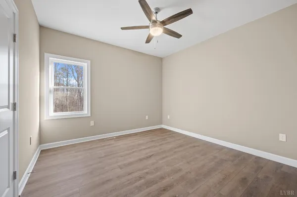 an empty room with a window and a fan