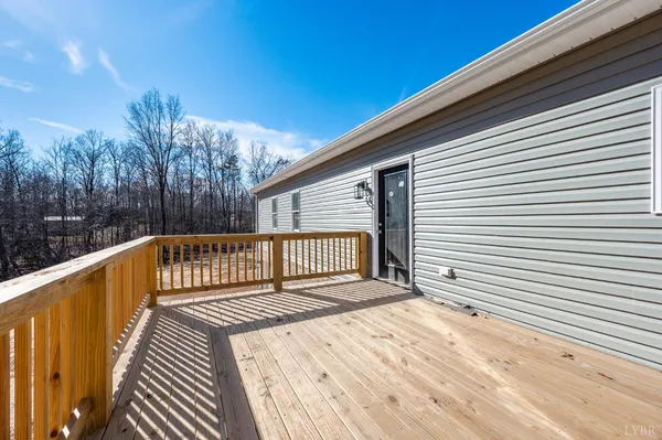 a view of deck with wooden floor and fence with a trees